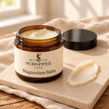 Concept render: open Magnesium Balm jar with an ivory balm swatch on a ceramic tile